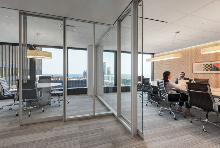 View of boardroom with glass walls and adjacent glass walled office