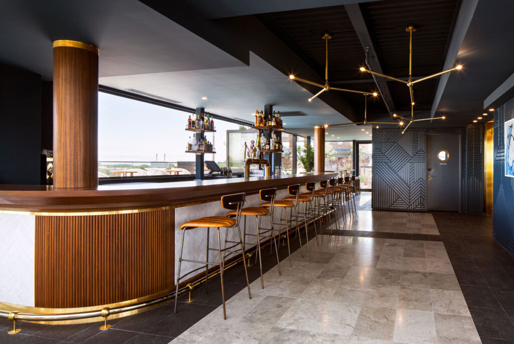 Elegant bar area with stools and gray marble flooring.