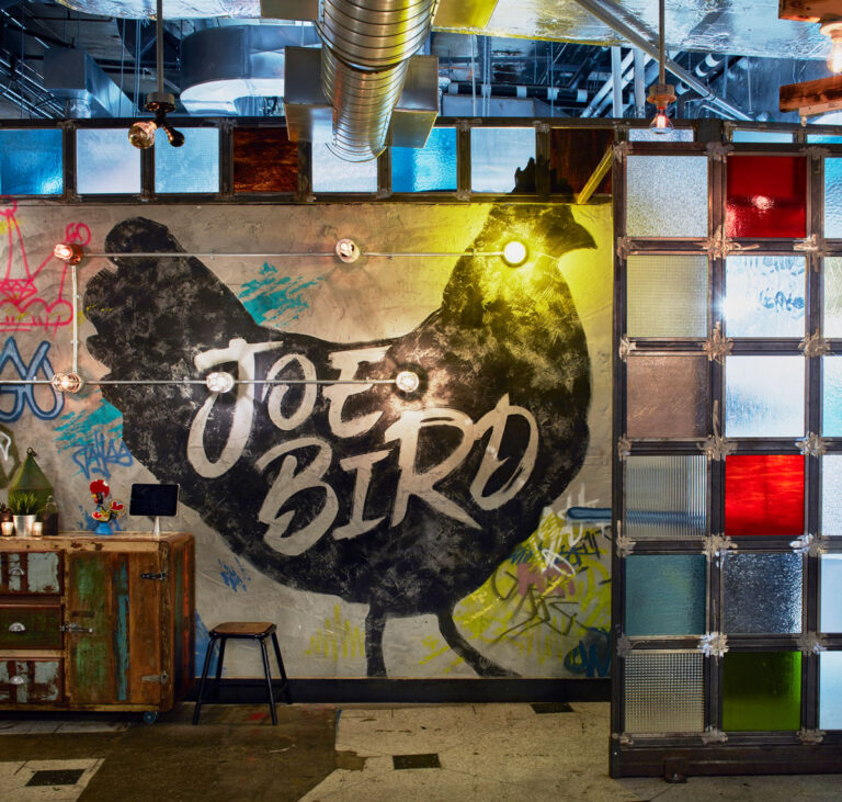 Accent wall with textured chicken and Joe Bird restaurant.