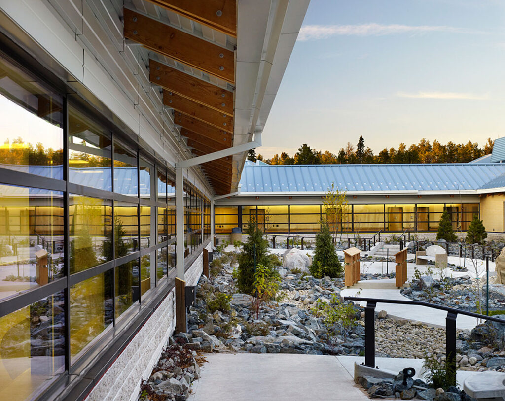 Landscaped interior courtyard with winding paved paths, and rock and evergreen gardens.