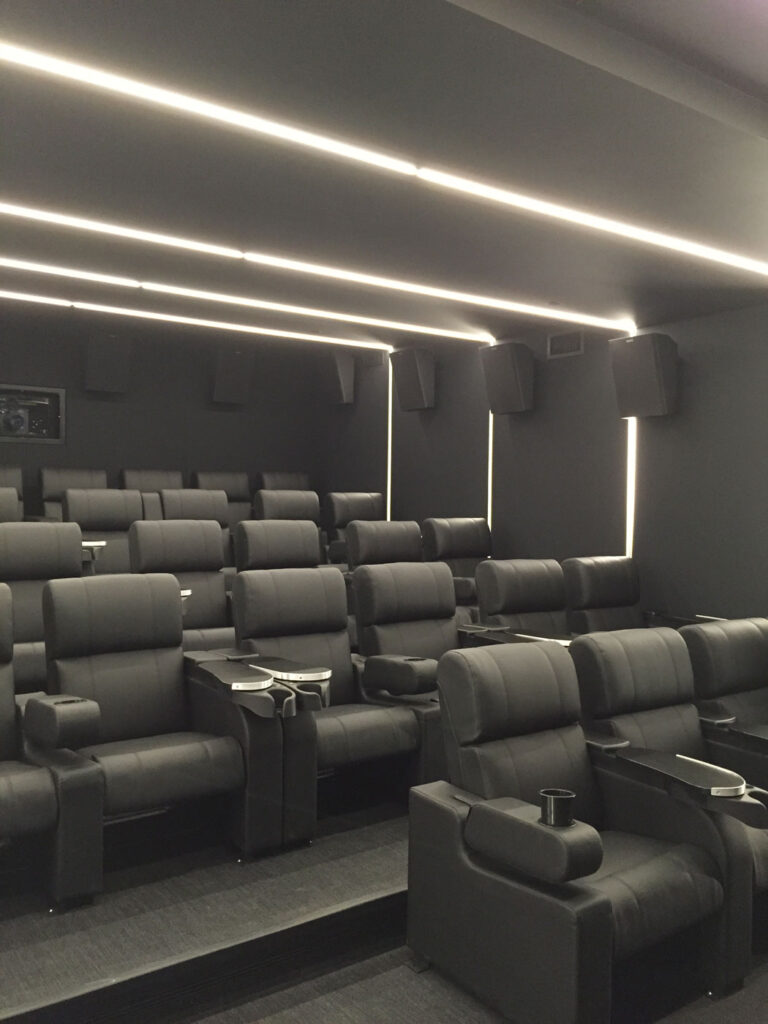 Employee screening area with black walls, surround sound and rows of comfy cinema seats.