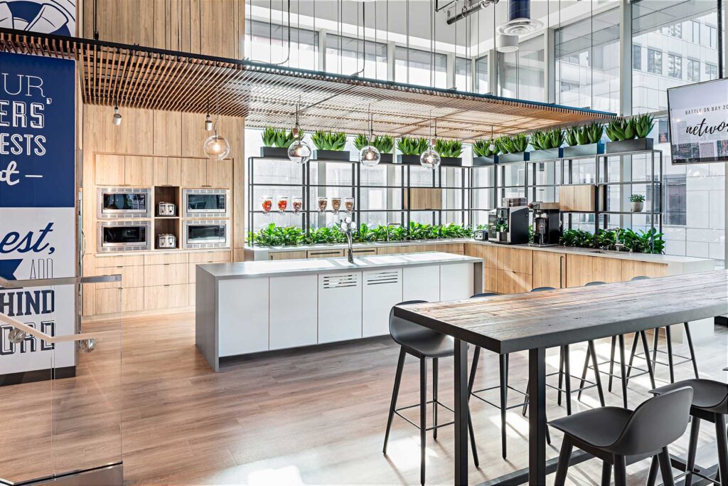 The employee cafe space is lined in pale wood and plants, with a tambour wood installation overhead.