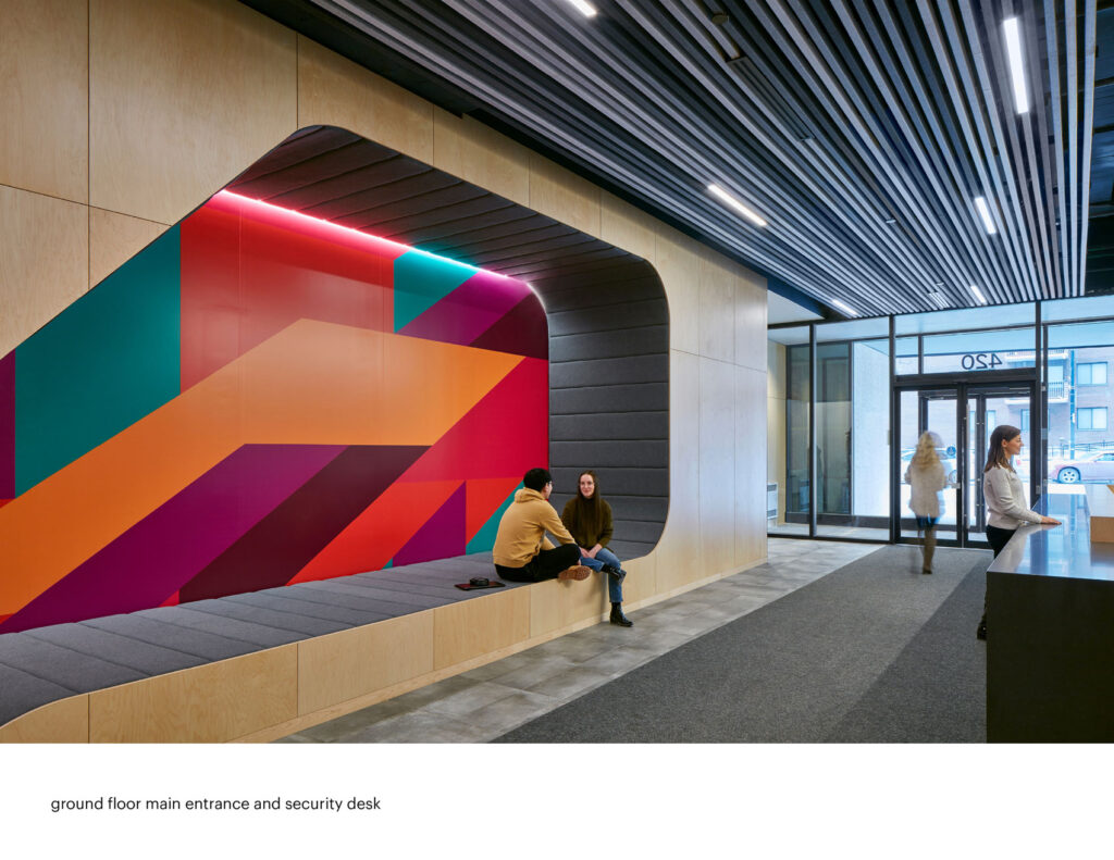 Entrance of student resident Campus 1 MTL with recessed seating alcove with coloured geometric graphic in behind.