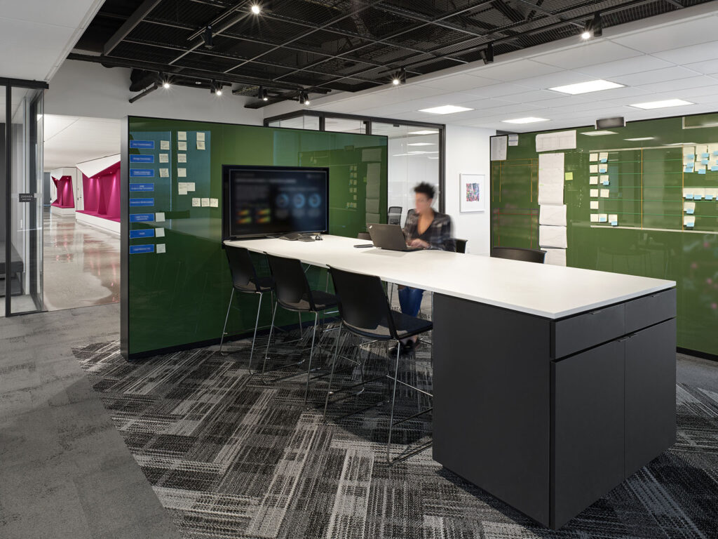 Alternative team space meant for tech huddles and creative thinking, with large bar height surface and writable walls all around.