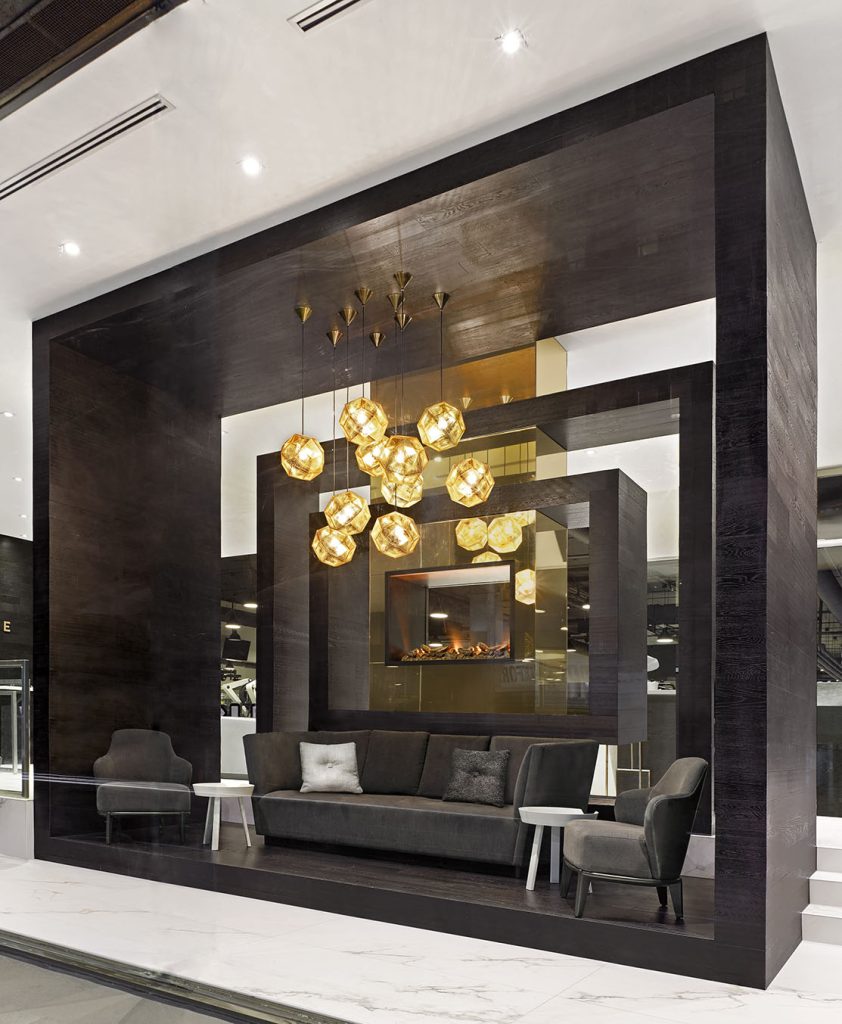 Elegant and modern lounge and waiting area by the fire place with a grouping of light pendants above.