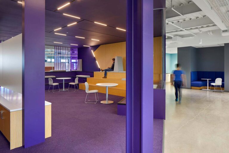 A workspace in purple is a soothing space for large meetings and breaks up the rest of the typical office components.