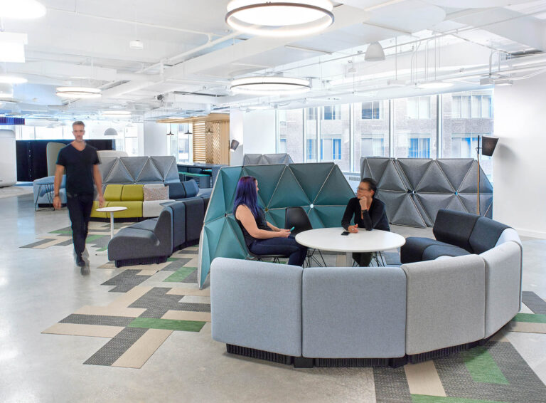 Central lounge area with curved modular seating and tall separations between seating areas for privacy