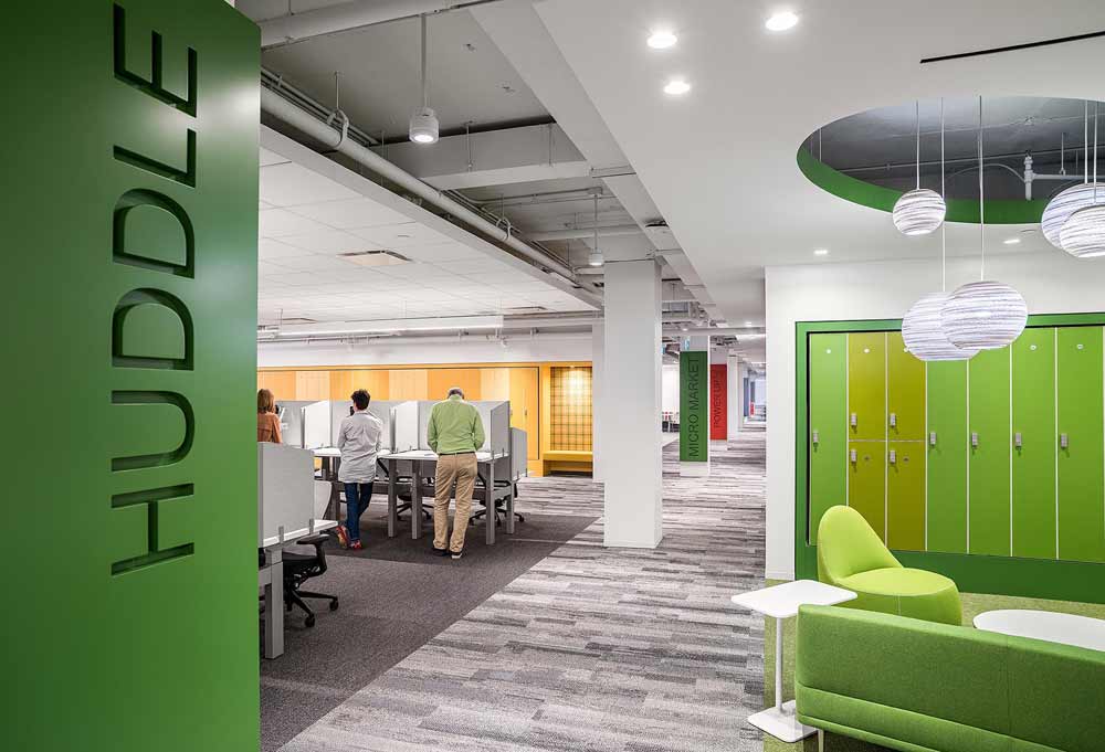Huddle area with sit to stand workstations, with pops of green