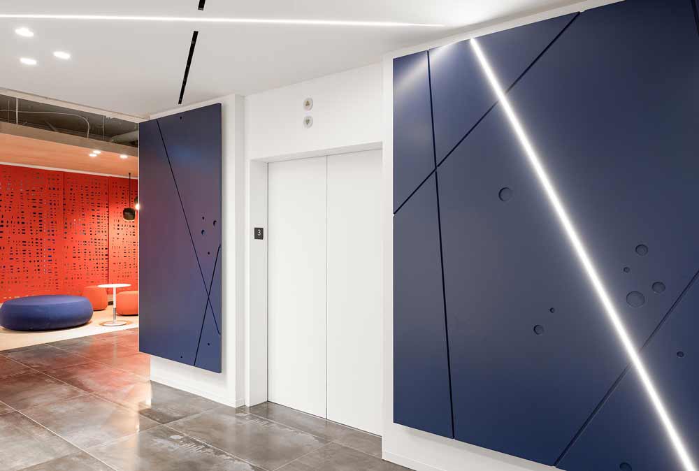 A blue feature wall with LED details in the elevator lobby