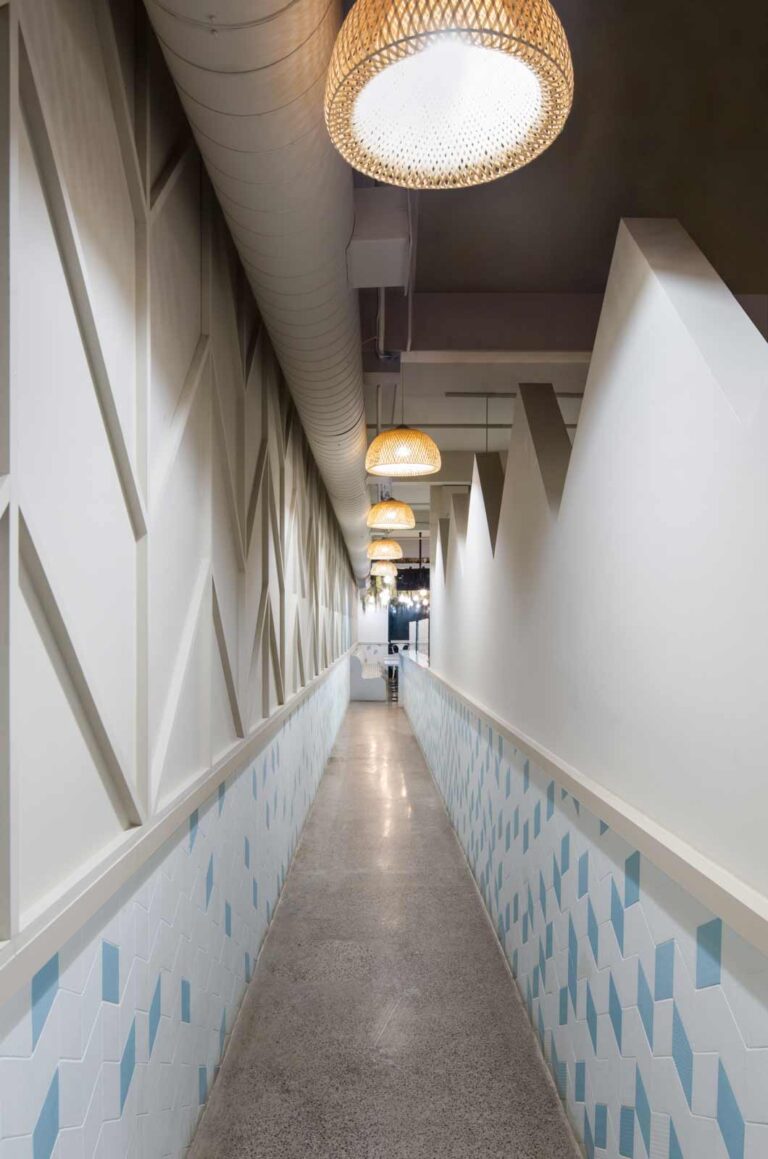 Chevron patterns along a walkway leading to the washrooms that mimic the look of building rafters