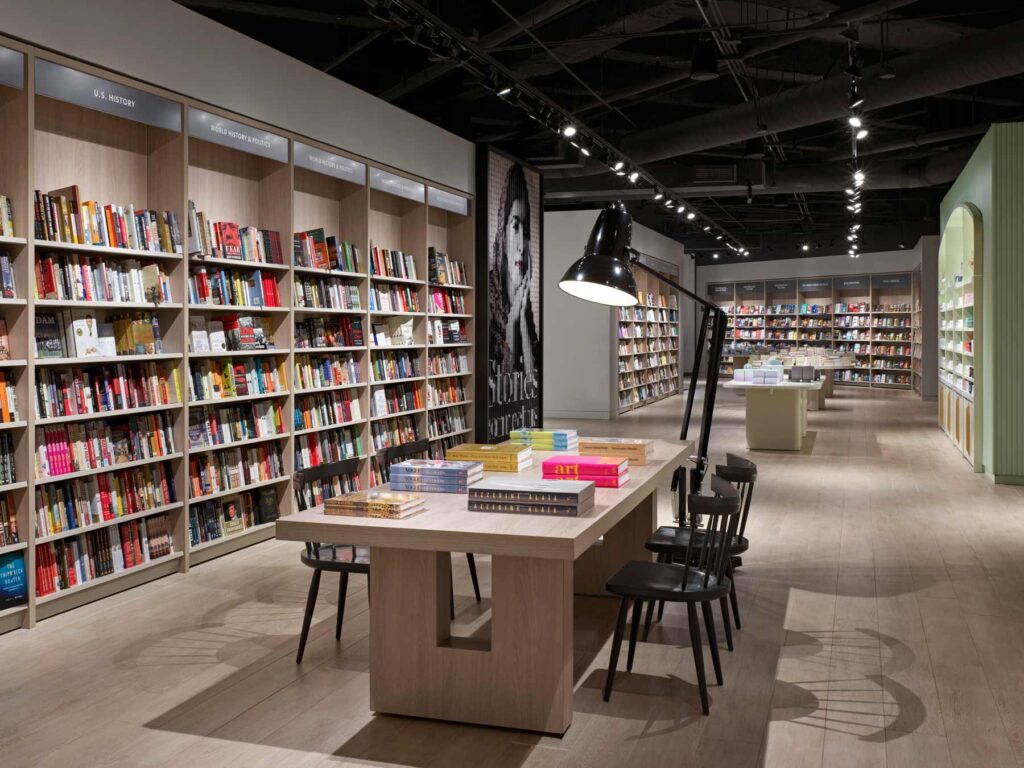 Large oversized table with chairs in the centre surrounded by walls of built-in shelves full of colourful books
