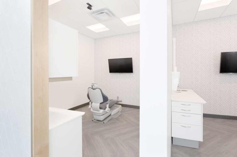 Predominantly white treatment rooms and wood finish flooring that adds warmth to the space