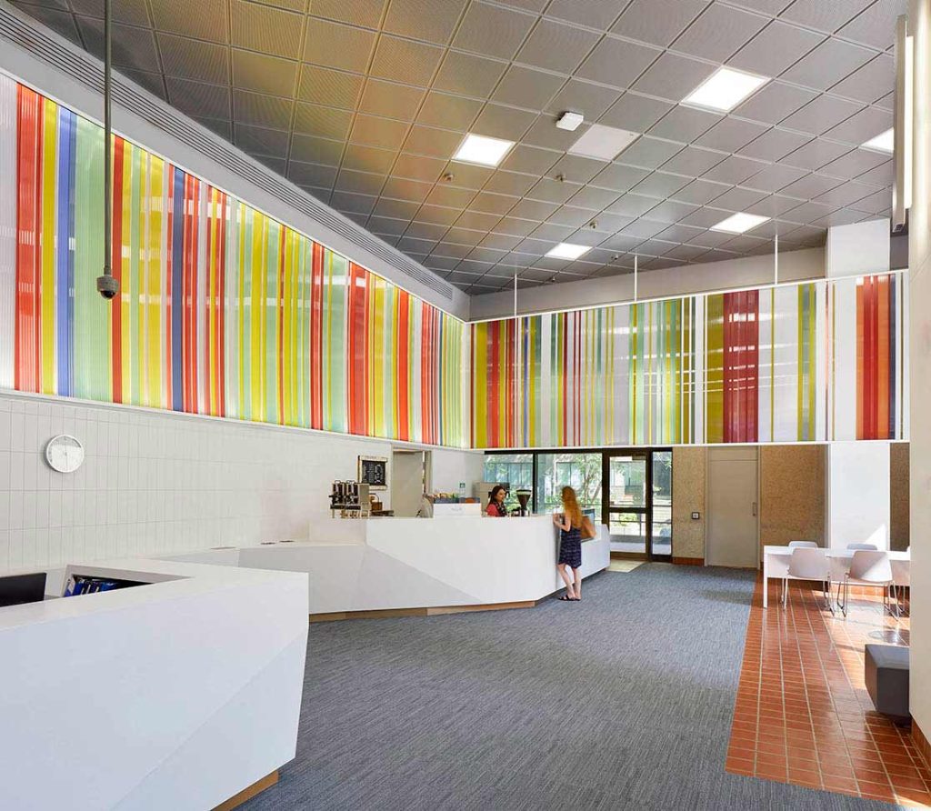 Cafe/kiosk area with the colorful ribbon stretching above it in the bright institute lobby.