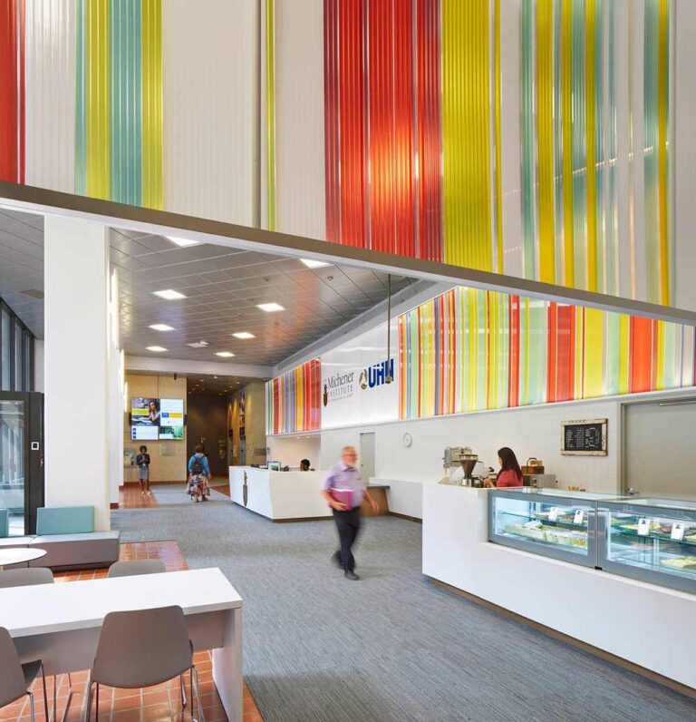 Wide view of the institute lobby. The reception desk and the colorful "ribbon" above it going around the perimeter of the entire space.