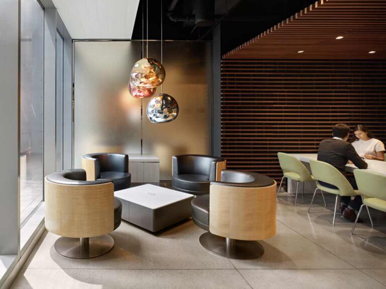 Club chairs by the window, anchored by large organic globes as pendants