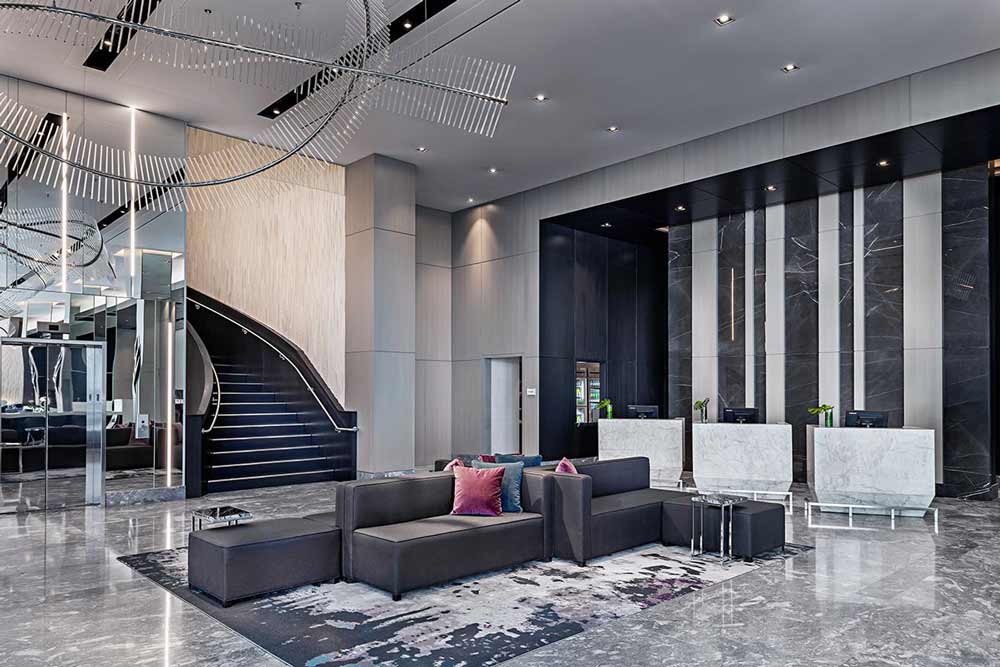 Reception area in modern finishes in gray color scheme, with a grouping of modern couches as the lounge setting