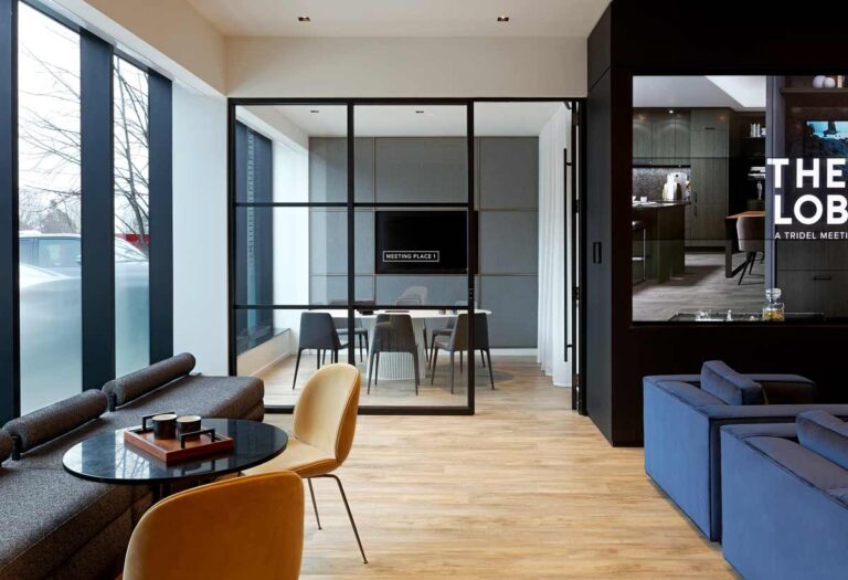 Beside the lounge area is the meeting room behind a glass wall with black detailing, modern furniture throughout