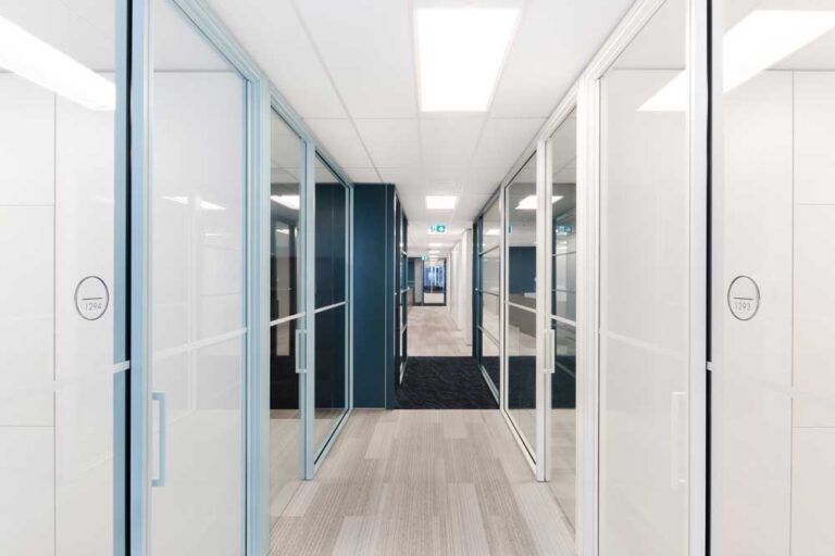 A long hallway with offices behind glass walls on both sides