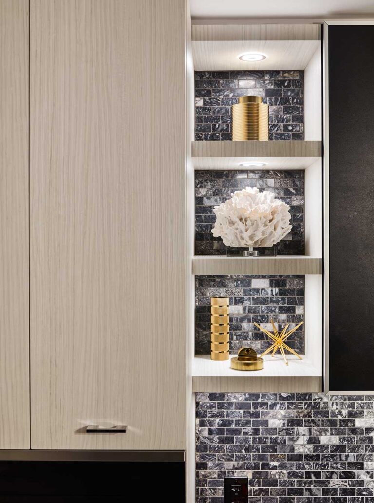 A ovely vignette of bathroom shelving in light wood against dark mosaic tiles on the wall
