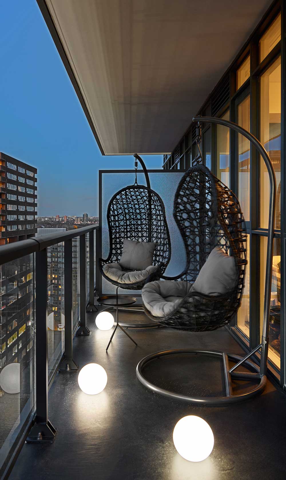 Balcony with hanging basket chairs and mood lighting on the floor