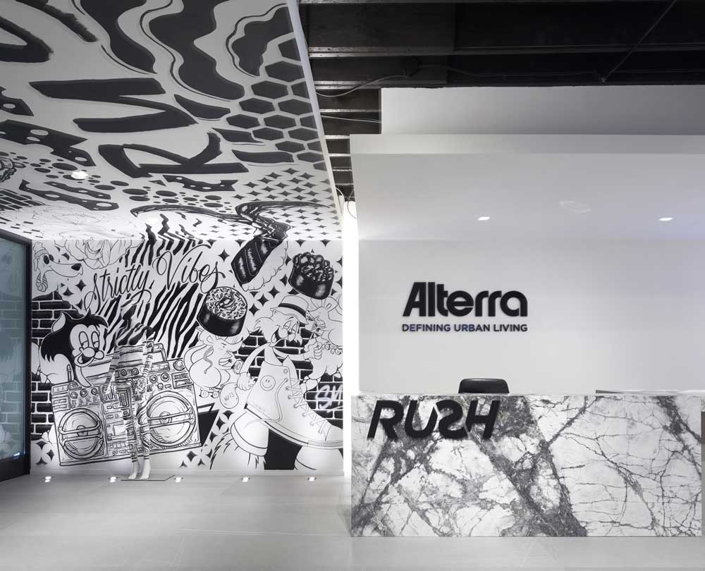 Reception area in the very front of the space enveloped in the black and white graffiti on wall and ceiling
