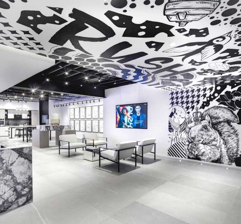 Lounge area in the very front of the space enveloped in the black and white graffiti on wall and ceiling