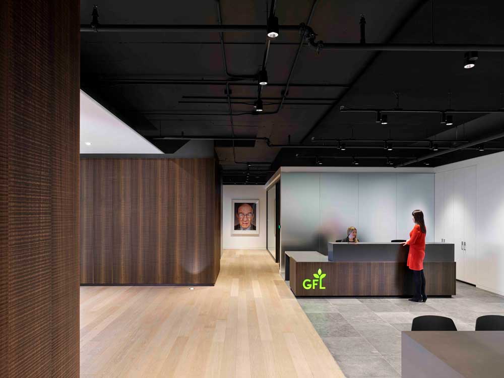 Reception area in simple clean lines and neutral colour scheme to make the green GFL logo on the side of the reception desk stand out