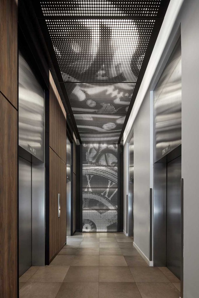 Elevator lobby with the clock inspired graphic detail running across the narrow tall ceilings