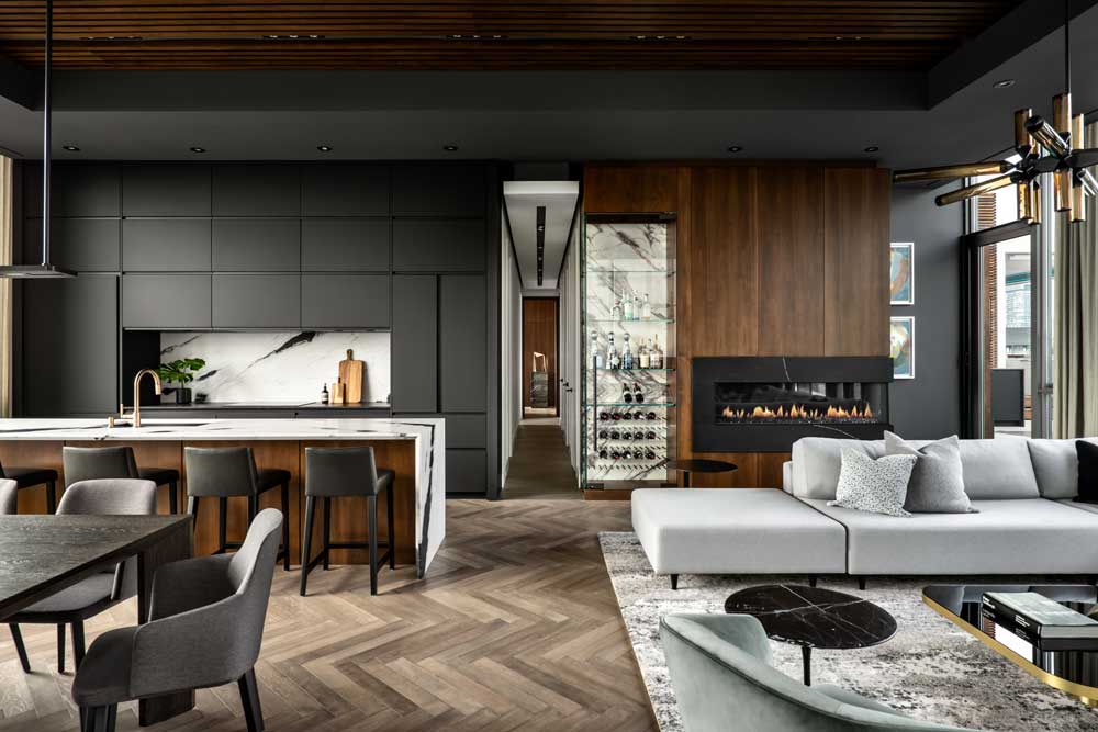 Dramatic design of the kitchen and living area, black wall in combination with wood details and stone elements in kitchen countertop and wine rack