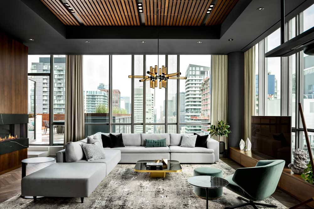 Living room featuring accent furniture pieces is completely surrounded by floor to ceiling windows and views of the outdoor patio and Toronto