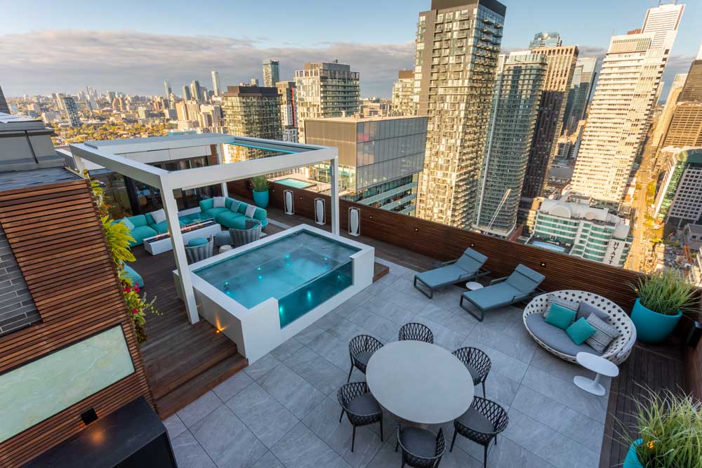 Magnificent Miami inspired outdoor space with plenty of seating, glass encased spa tub and turquoise accents