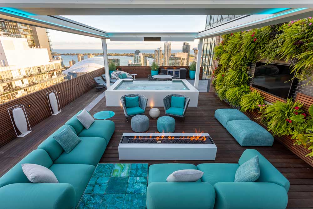 Magnificent Miami inspired outdoor oasis with plenty of seating, glass encased spa tub and turquoise accents, and views of the city and the lake
