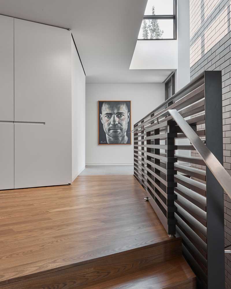 Stair railing with horizontal slats and an artwork