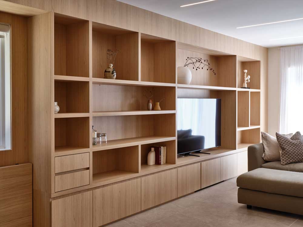 Living room built in shelving in the same coloured wood paneling as the walls