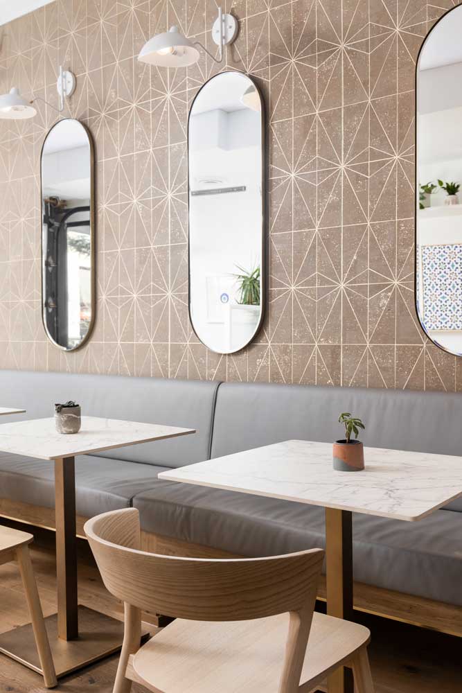 A detail of the beautiful geometric pattern and oval mirrors adorn the wall behind the seating benches