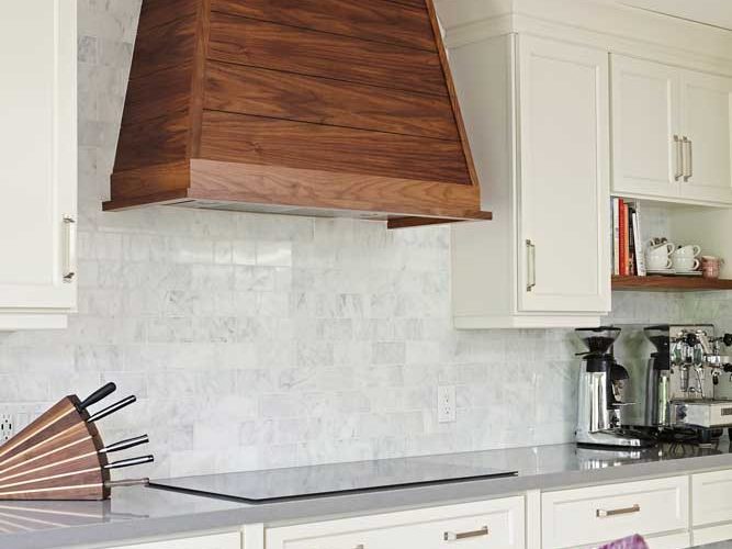 White kitchen with a wooden hood above the range