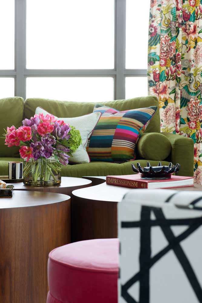 A colourful detail of the living room green sofa and freeform coffee tables