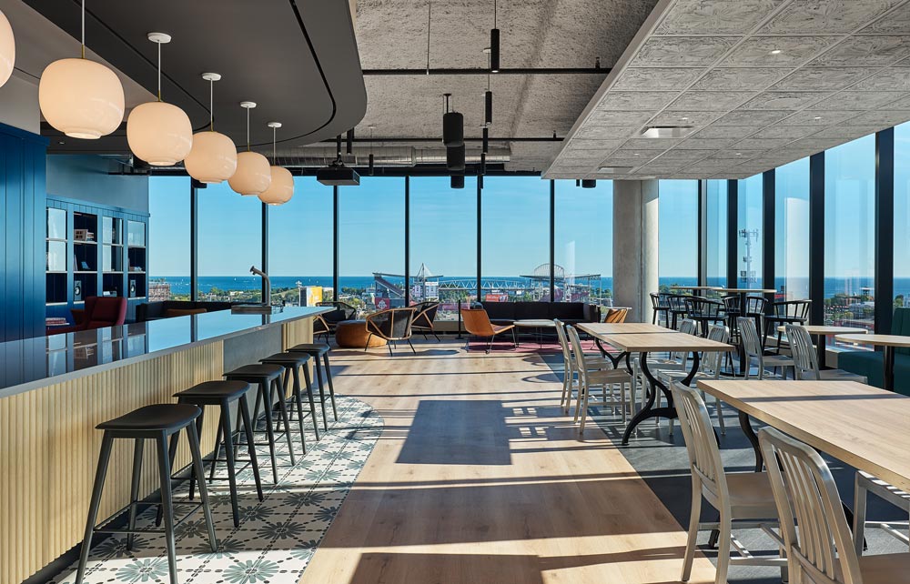 Cafe/bar area surrounded by floor to ceiling windows and views of the city and lake