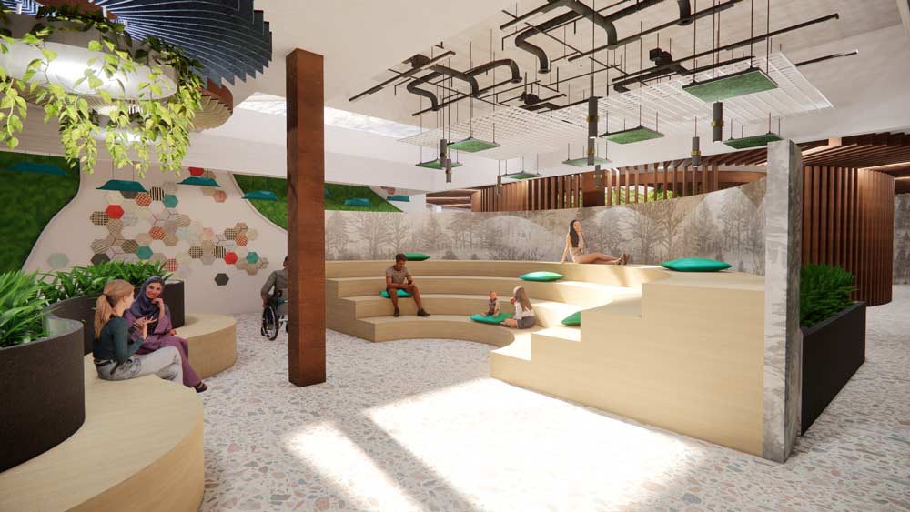 
A modern, well-lit indoor space with tiered seating, green cushions, and decorative wall elements. People are sitting and conversing on curved benches with integrated planters. The ceiling features industrial-style exposed piping and hanging greenery.