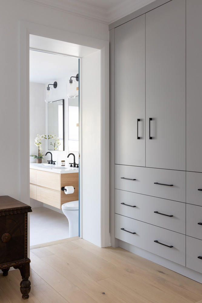 Entrance to the bathroom from the main bedroom, with simple floor to ceiling closet along the wall on the right