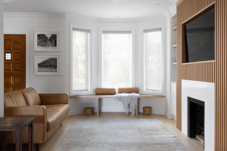 Living room in light and wood coloured finishes and slat detail on the fire place