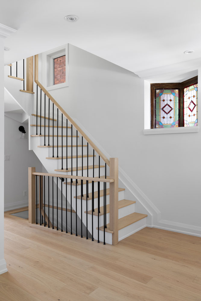 Simple stair case leading to the second floor and beside it the original window stained glass detail