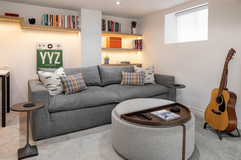 Office and lounge room in the basement with fun details like a guitar, book shelves and a big comfy grey sofa