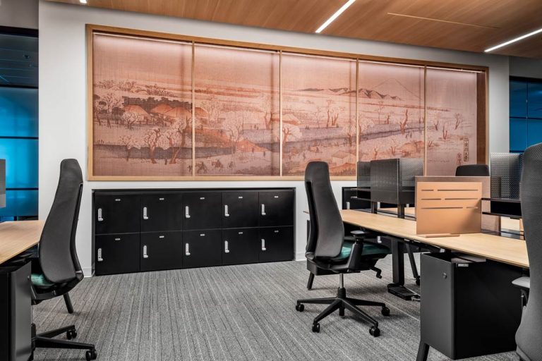 A large mural is visible on the wall in this co working space with work stations and cubicals