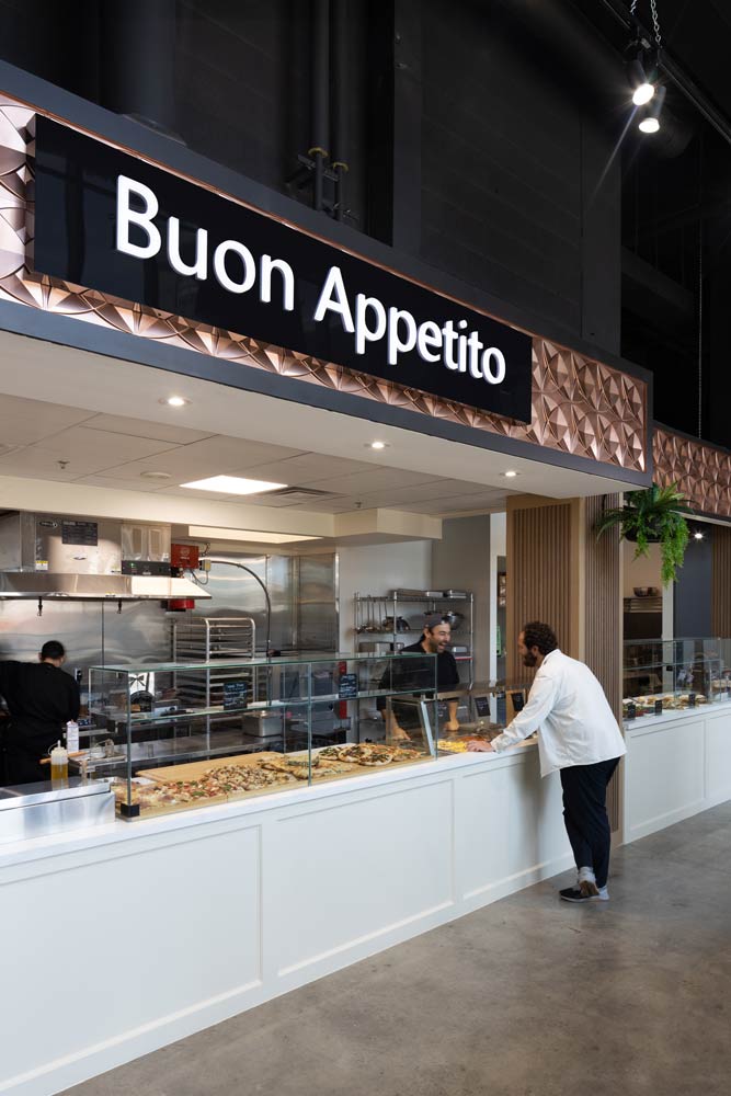 The ready made food counter offering Italian delicacies with a large sign above that says 