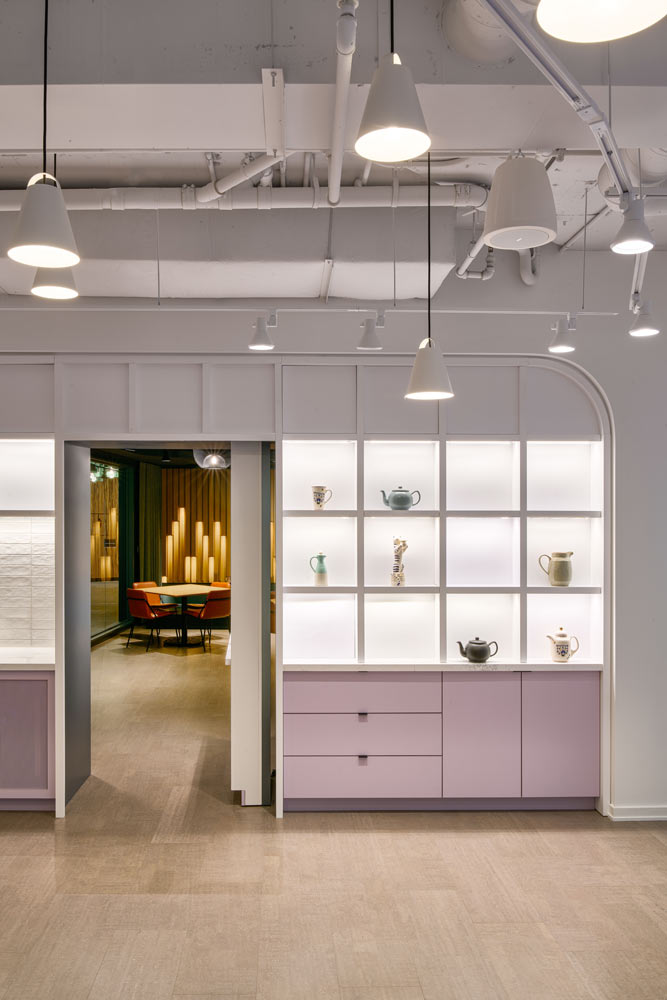 Built in shelves in white and dirty light pink colour next to the entrance to Karaoke lounge