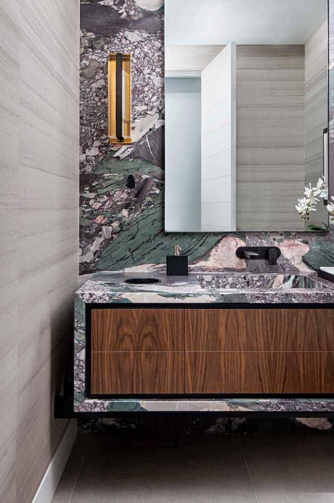 Powder room features a colourful marble backdrop to the wall hung vanity