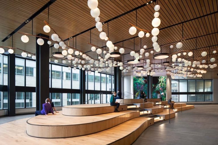 wooden tiered seating is inspired by the topography of Mount Royal and above is the bubble-clustered chandeliers. The whole space is surrounded by large windows on one side