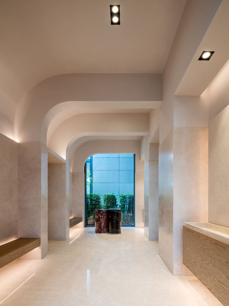 Gym and spa area with curved detailing on the ceiling, looking out to the greenery in the courtyard at the end of the room.