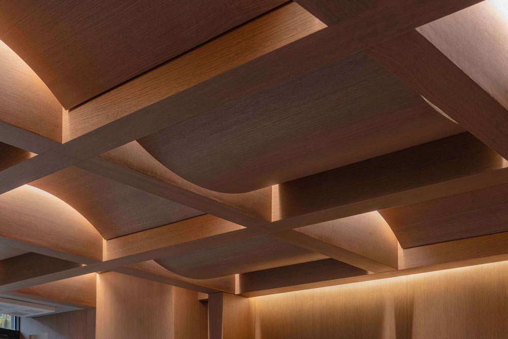 The ceiling made out of oak and imitates a traditional basketweave pattern with curved concave and convex oak millwork panels placed in between the new custom cross beams that were installed. 